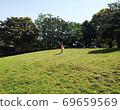 Children enjoying a walk in the size and greenery in a large park 69659569