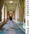 Children toddling in a beautifully decorated hotel corridor 69659574