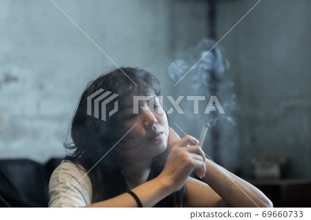 Asian girl smoking and feeling be absent-minded Asian girl smoking and feeling be absent-minded 69660733