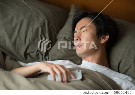 Sleeping face of a man sleeping in bed 69661493
