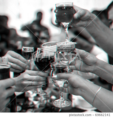 hands of a group of friends clinking glasses of wine and toasting 69662141