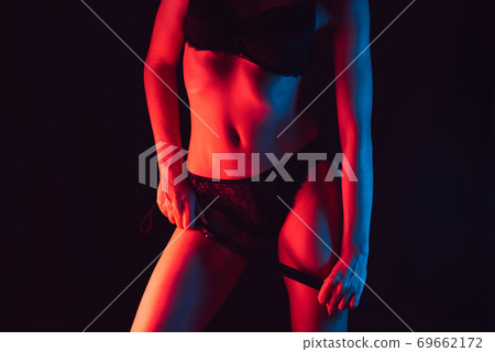 girl in lingerie with beautiful slim figure with leather whip in hand for BDSM 69662172