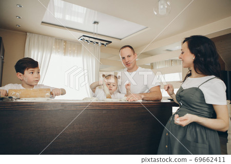 the family makes cakes. the children were covered in flour. dinner at the bakery. feast in the kitchen 69662411