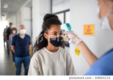 People with face masks, coronavirus, covid-19, measuring temperature and vaccination concept. People with face masks, coronavirus, covid-19, measuring temperature and vaccination concept. 69664218