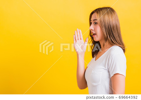 woman teen standing hand on mouth talking whispering secret rumor 69664392