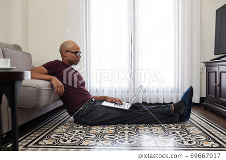 Man reading document on laptop Man reading document on laptop 69667017