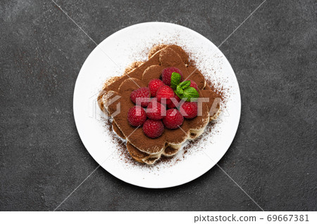 portion of Classic tiramisu dessert with raspberries on dark concrete background portion of Classic tiramisu dessert with raspberries on dark concrete background 69667381