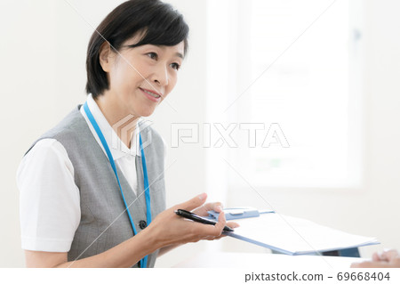 Female employee explaining [Middle] 69668404