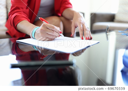 Female hand hold pen and sign contract. Female hand hold pen and sign contract. 69670339