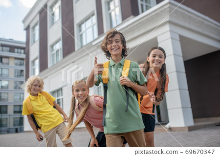 Schoolchildren playing in school yard and looking cheerful Schoolchildren playing in school yard and looking cheerful 69670347