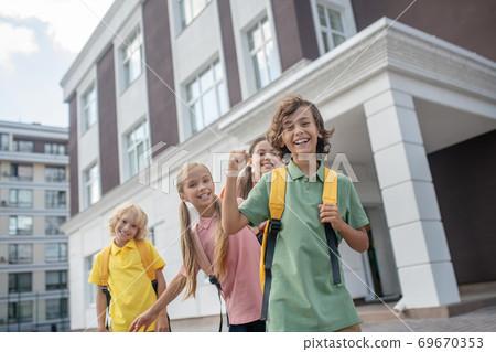 Schoolchildren playing in school yard and feeling good Schoolchildren playing in school yard and feeling good 69670353