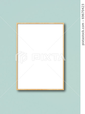 Wooden picture frame hanging on a light blue wall Wooden picture frame hanging on a light blue wall 69670423