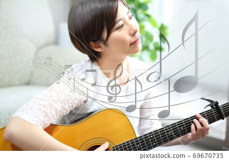Image of young woman with acoustic guitar 69670735