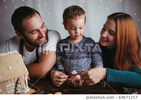 Mother, father and son packing Christmas cookies 69671257