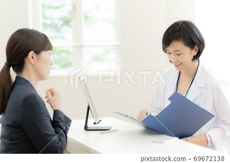 Business woman having an interview with an industrial physician 69672138