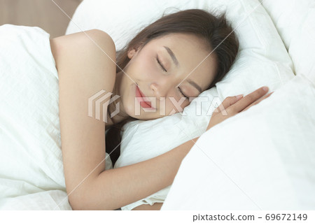 Asian women sleeping and sweet dream on white bed in bedroom Asian women sleeping and sweet dream on white bed in bedroom 69672149