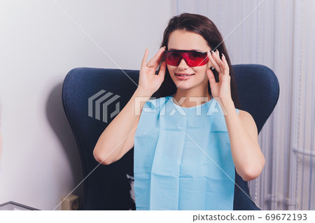 Close-up portrait of a female patient visiting dentist for teeth whitening in clinic,Teeth whitening procedure. 69672193