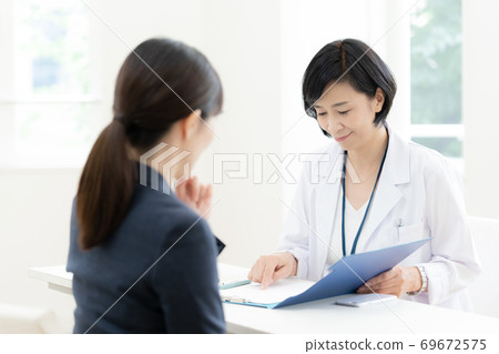 Business woman having an interview with an industrial physician 69672575