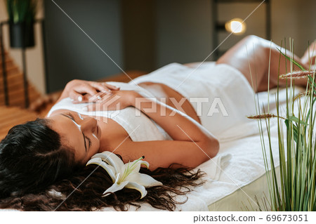 Beautiful young woman in the massage salon with brown curly hair and healthy skin. Masseur and patient concept. 69673051