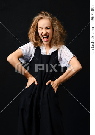 Portrait of screaming girl with hands on her waist Portrait of screaming girl with hands on her waist 69673093