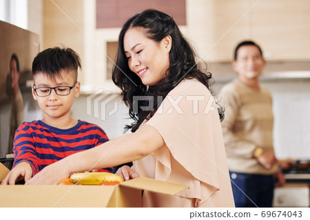 Unpacking fruits and vegetables Unpacking fruits and vegetables 69674043