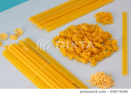 Different types of pasta, blue background. Different types of pasta, blue background. 69674096