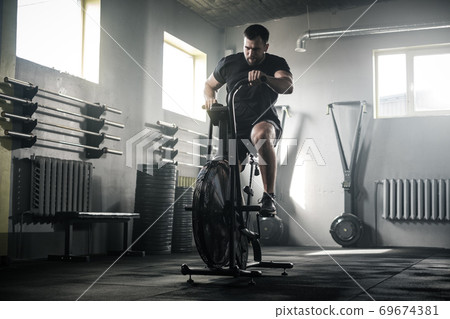 Sportive Man Train Legs On Stationary Bike . Sportive Man Train Legs On Stationary Bike . 69674381