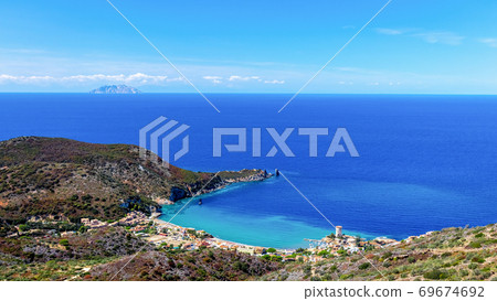 Beautiful seascape with beach and coastal town with a lighthouse in the bay. Giglio Island 69674692