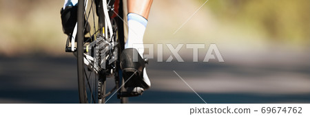Racing- bike detail on gear wheels and feet Racing- bike detail on gear wheels and feet 69674762