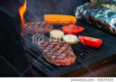 Beef steaks on the grill with flames Beef steaks on the grill with flames 69674816