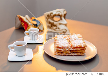 Typical Italian carnival fritters (Chiacchiere di Carnevale) dusted with powdered. Typical Italian carnival fritters (Chiacchiere di Carnevale) dusted with powdered. 69674880
