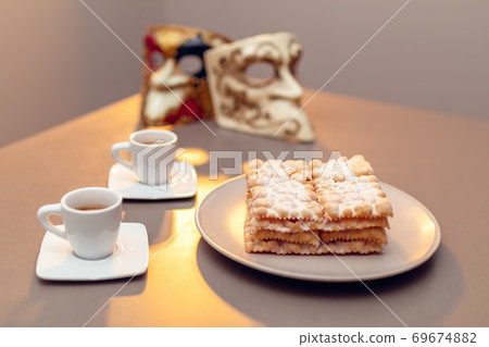 Typical Italian carnival fritters (Chiacchiere di Carnevale) dusted with powdered. Typical Italian carnival fritters (Chiacchiere di Carnevale) dusted with powdered. 69674882