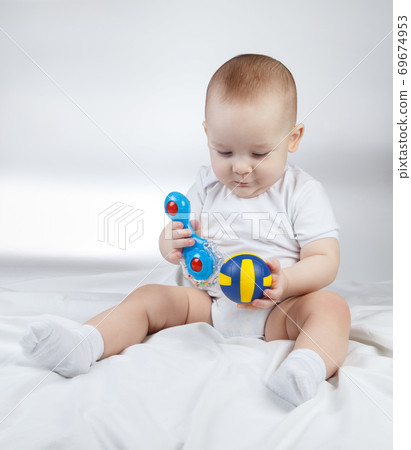 Photo of a ten-month-old choosing baby between rattle and ball 69674953