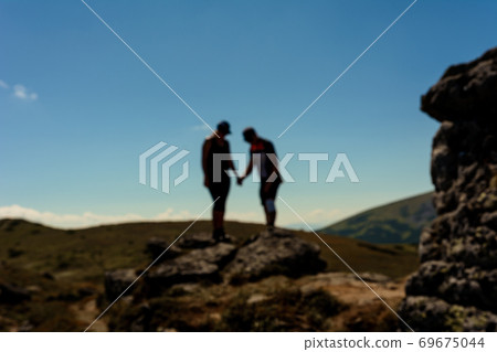 Silhouette of a couple on top of a mountain, tourists on top of a Carpathian mountain, Montenegrin ridge. Silhouette of a couple on top of a mountain, tourists on top of a Carpathian mountain, Montenegrin ridge. 69675044