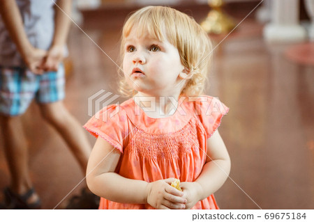 little blonde girl in dress in Orthodox Church little blonde girl in dress in Orthodox Church 69675184