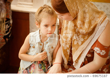 mum and daughter sit on bench in Church Orthodox mum and daughter sit on bench in Church Orthodox 69675187