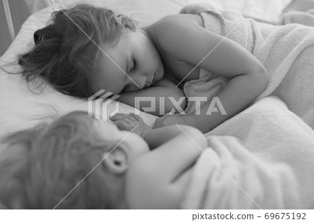small girl with sister sleep together in bed home small girl with sister sleep together in bed home 69675192