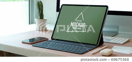 Mock up digital tablet on computer desk with smartphone and accessories in office Mock up digital tablet on computer desk with smartphone and accessories in office 69675368