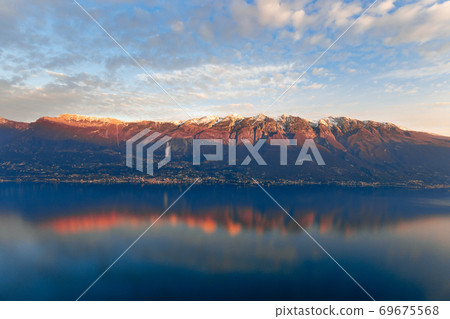View of Monte Baldo mountain (Italian Alps) colored by the rays of the setting sun View of Monte Baldo mountain (Italian Alps) colored by the rays of the setting sun 69675568