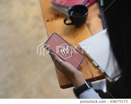 Female using mock up smartphone, looking for an idea and write it down in notebook 69675575