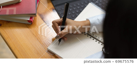 Female writing on blank notebook with supplies Female writing on blank notebook with supplies 69675576