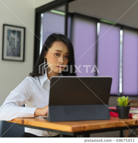 Female office worker working with digital tablet on wooden worktable 69675851