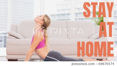 Caucasian woman practising yoga with words Stay Home during coronavirus covid19 pandemic 69676574