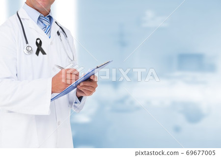 Mid section of male doctor with black ribbon on robe taking notes in the hospital Mid section of male doctor with black ribbon on robe taking notes in the hospital 69677005