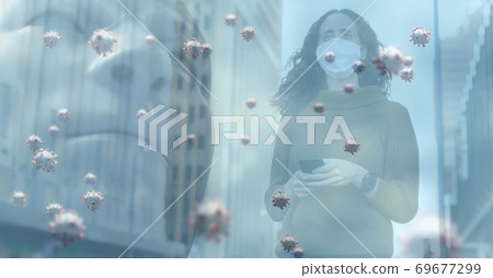 Covid-19 cells against blue backgroundwoman wearing face mask walking on the street 69677299