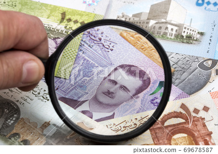 Syrian money in a magnifying glass a business background Syrian money in a magnifying glass a business background 69678587