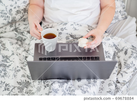 top view computer with tea and marshmallows on bed top view computer with tea and marshmallows on bed 69678884