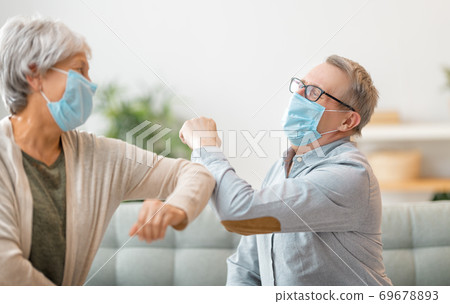 Senior couple greeting bumping elbows 69678893