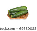 uncooked whole fresh zucchini in bamboo basket on white background 69680888