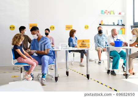 People with face mask getting vaccinated, coronavirus, covid-19 and vaccination concept. 69682650